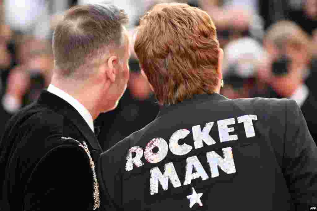 British singer-songwriter Elton John (R) and his husband Canadian filmmaker David Furnish arrive for the screening of the film "Rocketman" at the 72nd edition of the Cannes Film Festival in Cannes, southern France, on May 16, 2019.