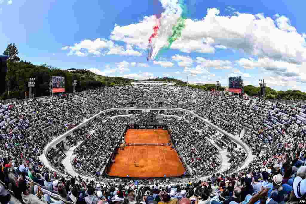 The Frecce Tricolori air squadron flies over the Foro Italico as Serbia's Novak Djokovic plays against Canada's Denis Shapovalov during their ATP Masters tournament tennis match in Rome, Italy.
