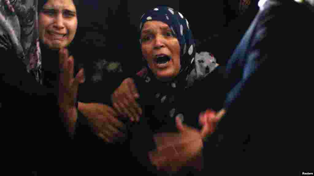 The mother, center, of Palestinian militant Mahmoud Abbas, who medics said was killed by an Israeli airstrike, mourns during his funeral in Gaza City, Aug. 24, 2014.