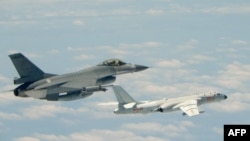 台灣F16戰機監控伴飛在台灣南部巴士海峽上空飛行的中國空軍H-6K轟炸機。(2018年5月11日)