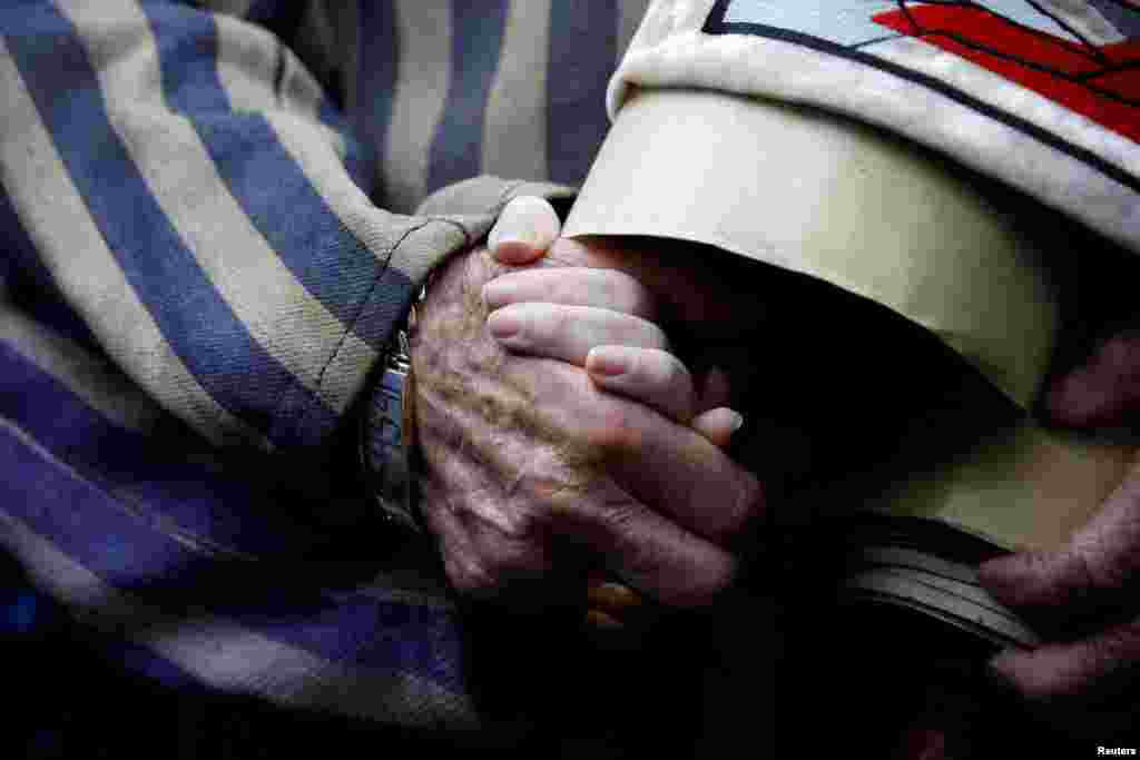 Holocaust survivor Edward Mosberg holds the hand of his granddaughter Jordana Karger as he arrives to take part in the annual "March of the Living" to remember the horror of the Holocaust at the former Nazi death camp Auschwitz, in Oswiecim, Poland.