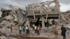 Somali security forces and others gather and search for bodies near destroyed buildings at the scene of Saturday's blast, in Mogadishu, Somalia, Oct. 15, 2017.