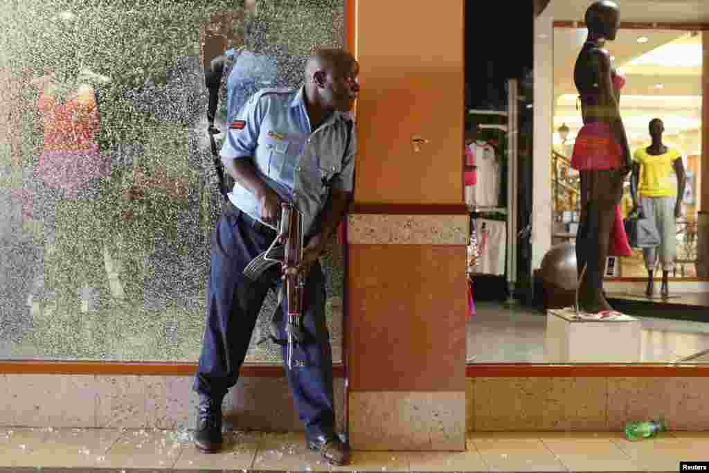 A police officer tries to secure an area inside the Westgate Shopping Center where gunmen went on a shooting spree in Nairobi, Sept. 21, 2013.