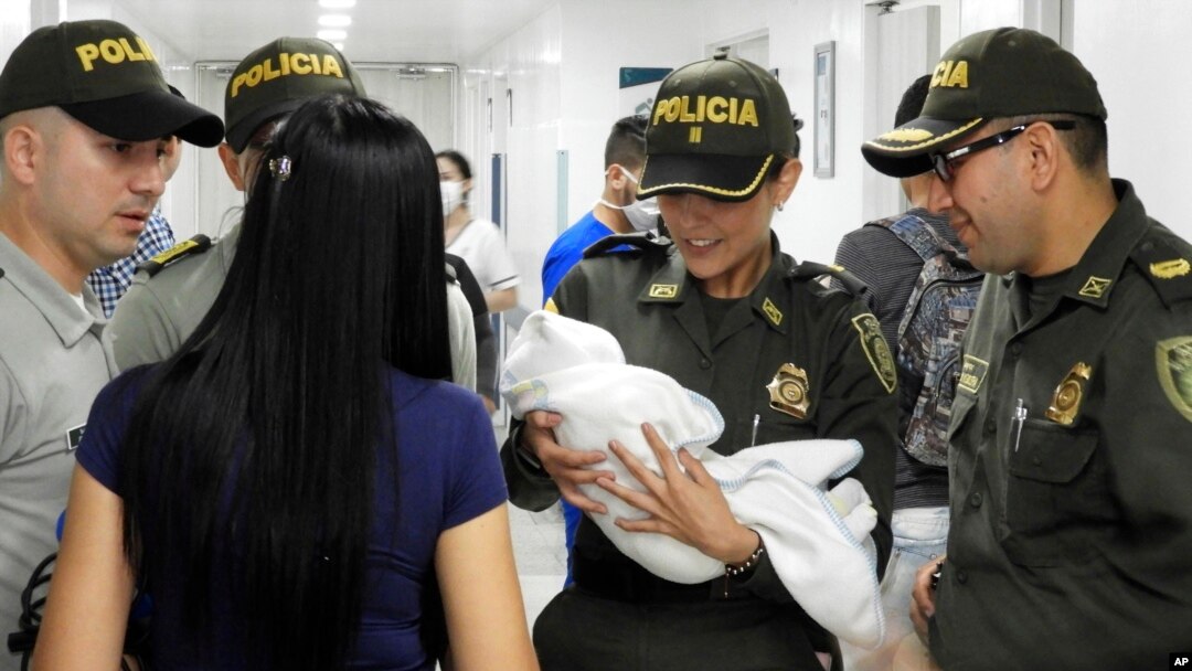 Policías colombianos llevan al hospital a una recién nacida abandonada descubierta junto a un auto cerca de un estadio en Cúcuta, Colombia. Una nota encontrada junto a la bebé dice que la niña se llama Ángela y que la madre no tiene medios para cuidarla. Foto AP, cortesía de la Policía Nacional de Colombia.