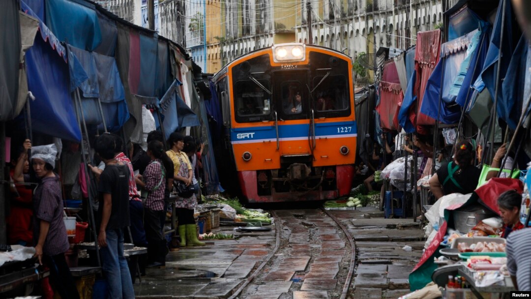 FILE - A Train arrives in Maeklong, in Samut Songkhram province, Thailand.