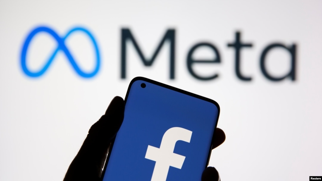 A smartphone with Facebook's logo is seen in front of displayed Facebook's new rebrand logo Meta in this illustration taken Oct. 28, 2021. 