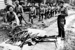 Picture released on August 1945 of Japanese soldiers laying down arms in front of Soviet officers. (AFP)