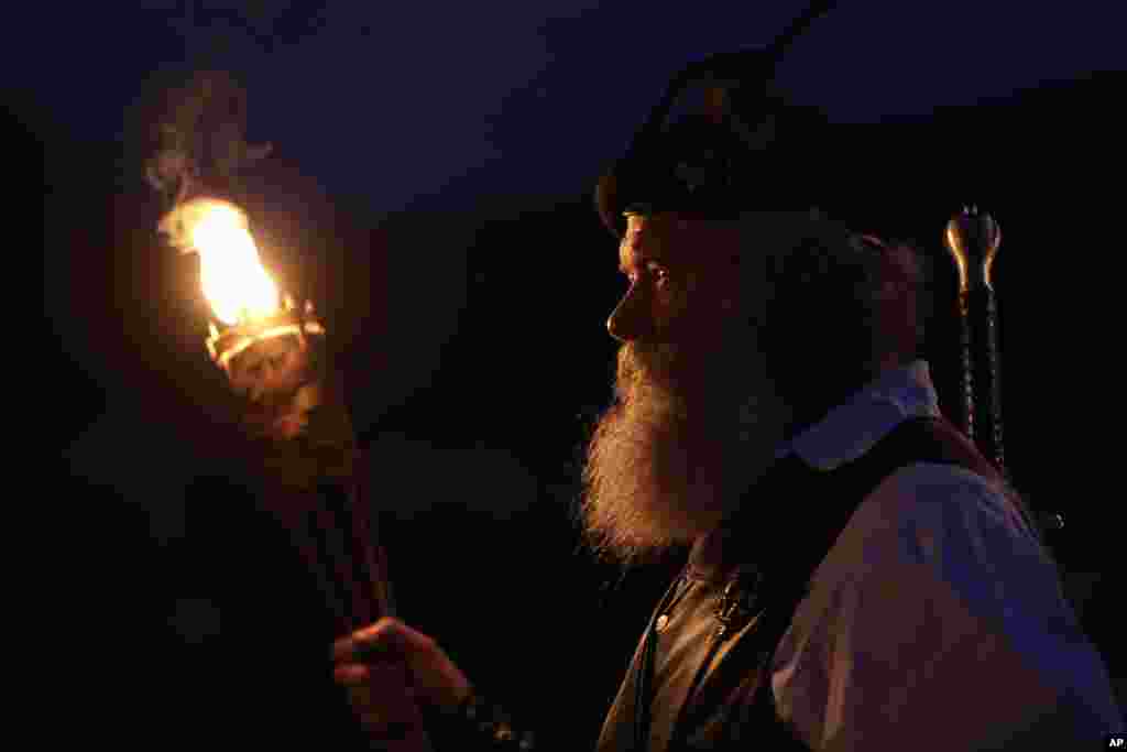Al Thompson, of Milan, Ind., waits to announce his clan's arrival during the opening torchlight service of the 64th annual Grandfather Mountain Highland Games at MacRae Meadows in Linville, N.C., July 11, 2019. The games celebrate the history and culture of Scottish people in North Carolina.