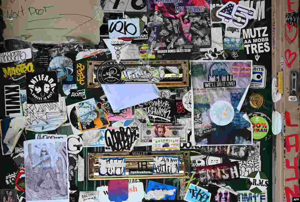 A letter is placed in the mail slot in a graffiti-covered door in the Bushwick section of Brooklyn, New York.
