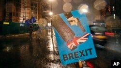 Vehicles drive past an anti-Brexit placard that is placed near the Parliament in London, Jan. 29, 2019. 