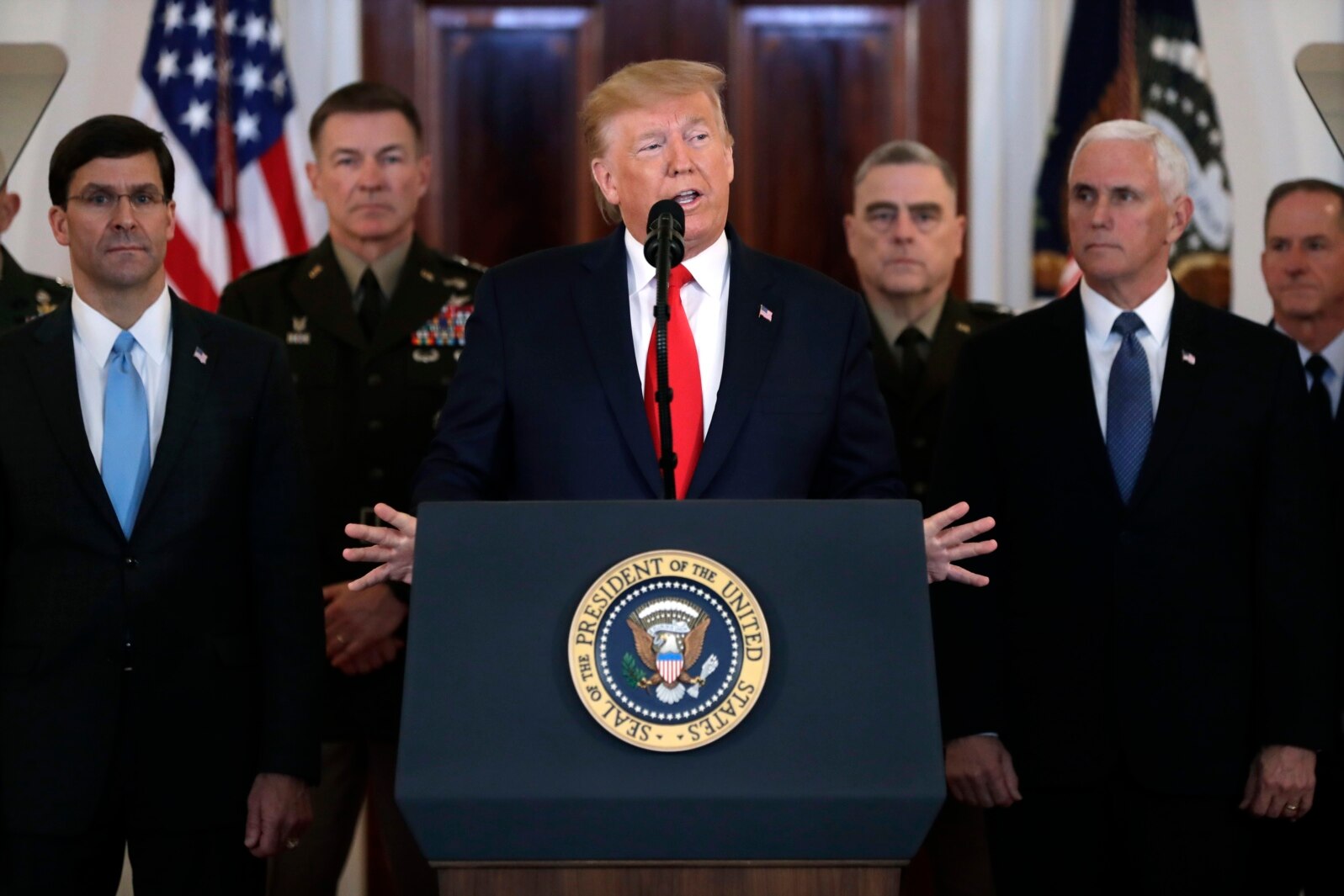 President Donald Trump addresses the nation on the ballistic missile strike that Iran launched against Iraqi air bases housing U.S. troops, Jan. 8, 2020, in Washington, as Vice President Mike Pence and others looks on.