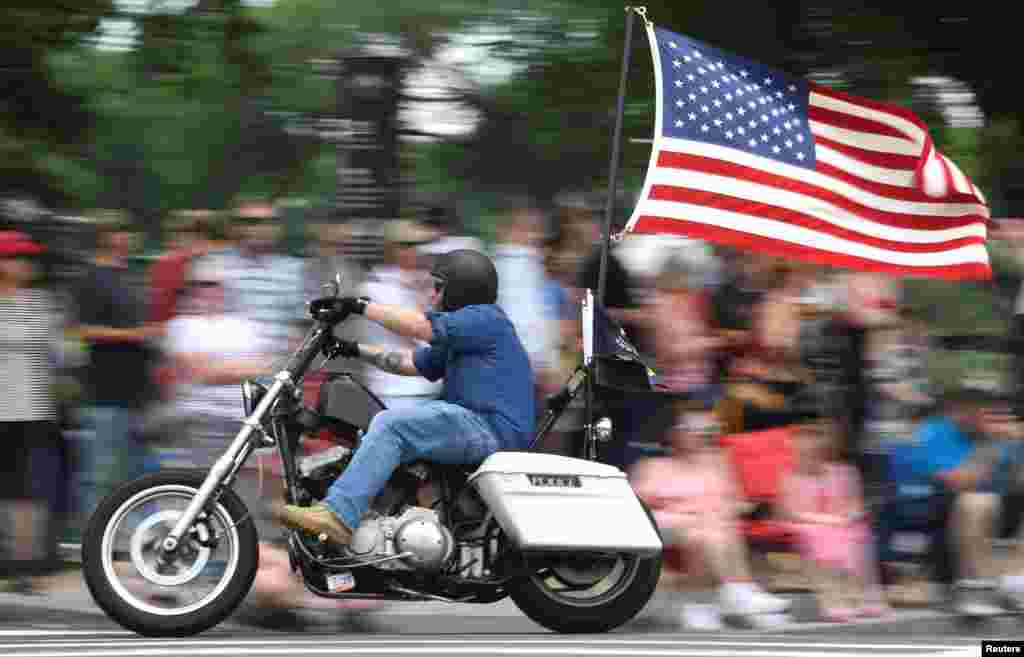 A motorcycle rider with American flag fluttering passes crowds during the 32nd Annual, and possibly final, Rolling Thunder "Ride for Freedom" during Memorial Day weekend to support veterans and call attention to POWs and MIAs, in Washington, D.C., May 26, 2019.