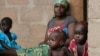 FILE - A mother sits with her children in Wurojuli, Gombe State, Nigeria, Sept. 2, 2014. Africa's children may account for nearly half of the world’s poor by 2030, a report by the Overseas Development Institute says.