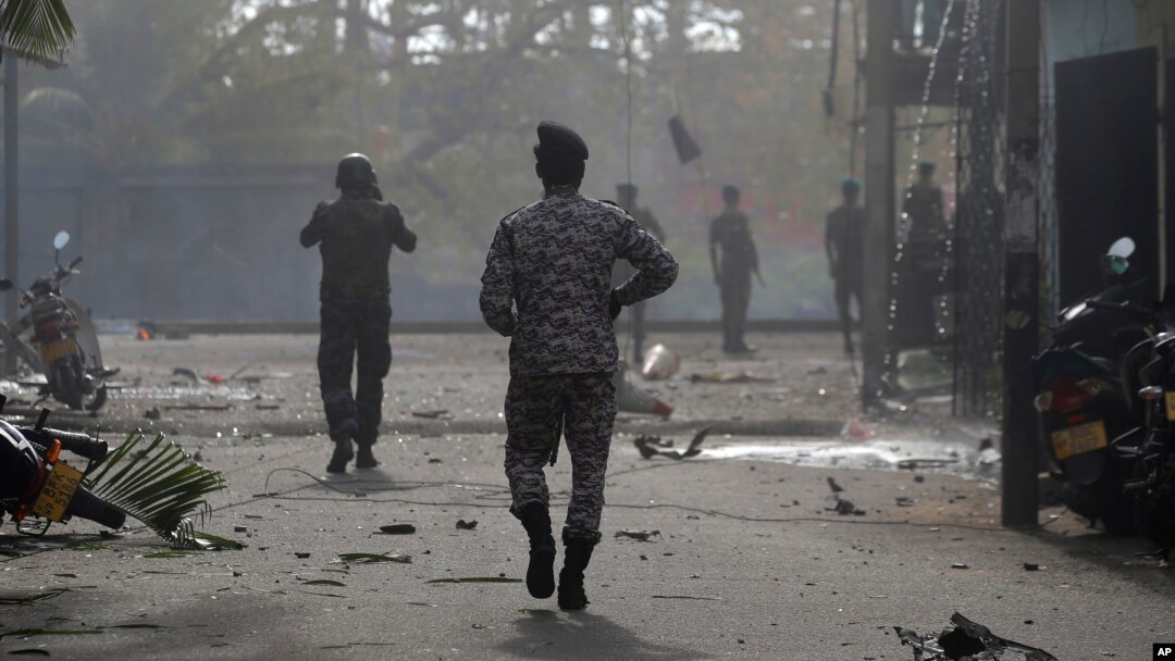 Sri Lankan security forces approach the site after a vehicle parked near St. Anthony's shrine exploded in Colombo, Sri Lanka, Monday, April 22, 2019.
