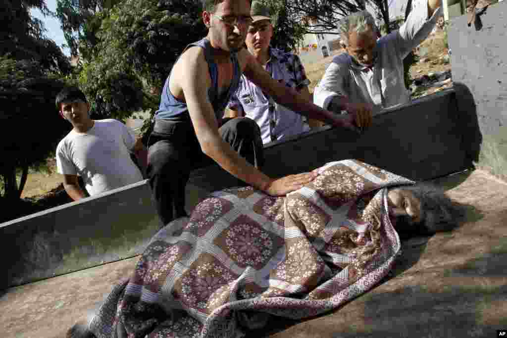 Syrians wounded in an air strike that hit their homes evacuate a field hospital after a second air strike in Azaz on the outskirts of Aleppo, August 15, 2012.