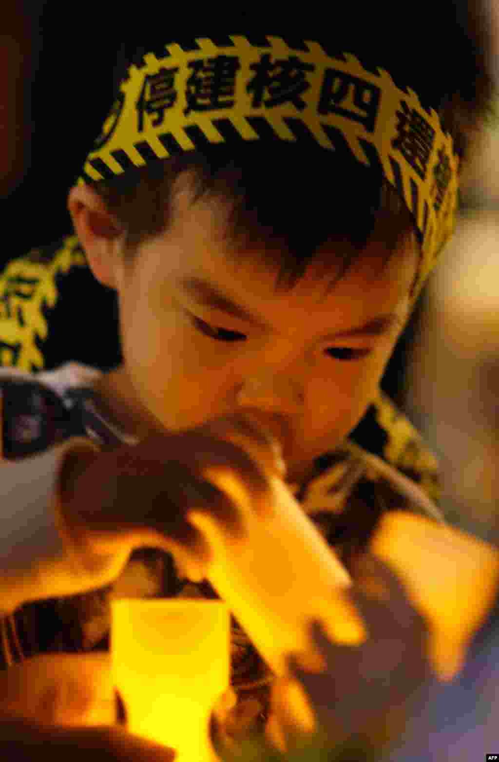 A boy wears a headband that reads "shut down the fourth nuclear power plant" during an anti-nuclear demonstration in Taipei, Taiwan.