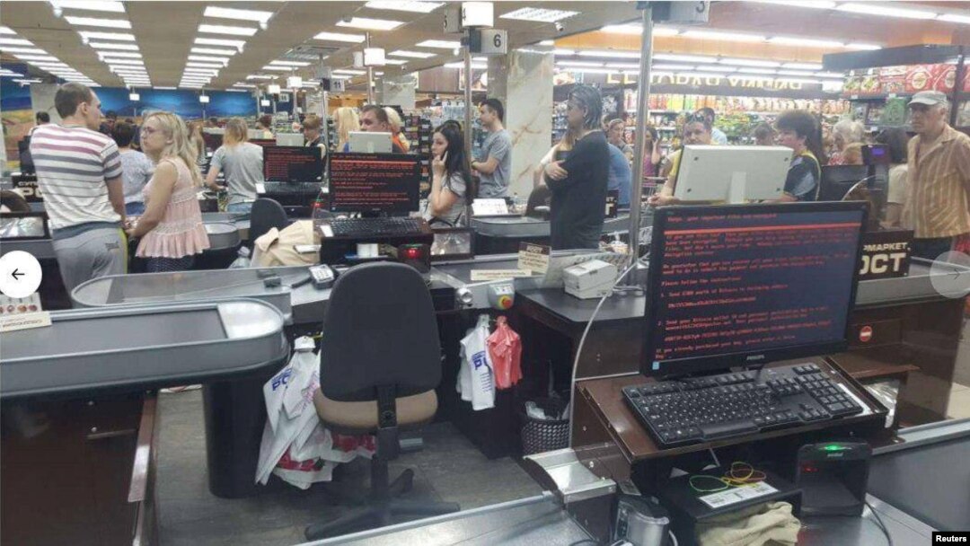 Customers queue in 'Rost' supermarket in Kharkiv, Ukraine, June 27, 2017 in this picture obtained from social media. An infected computer in the foreground shows a ransom message on the screen.