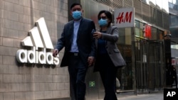 北京市民走過一家商場的阿迪達斯和H&M商店。（2021年3月25日）
