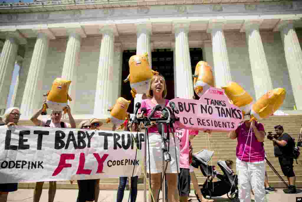 U.S. activist Medea Benjamin, co-founder of the anti-war group Code Pink holds a sign that reads "Tanks But No Tanks DC Residents," as she speaks at a news conference, July 2, 2019, in front of the Lincoln Memorial in Washington, near where workers set up for President Donald Trump's 'Salute to America' event honoring service branches on Independence Day.