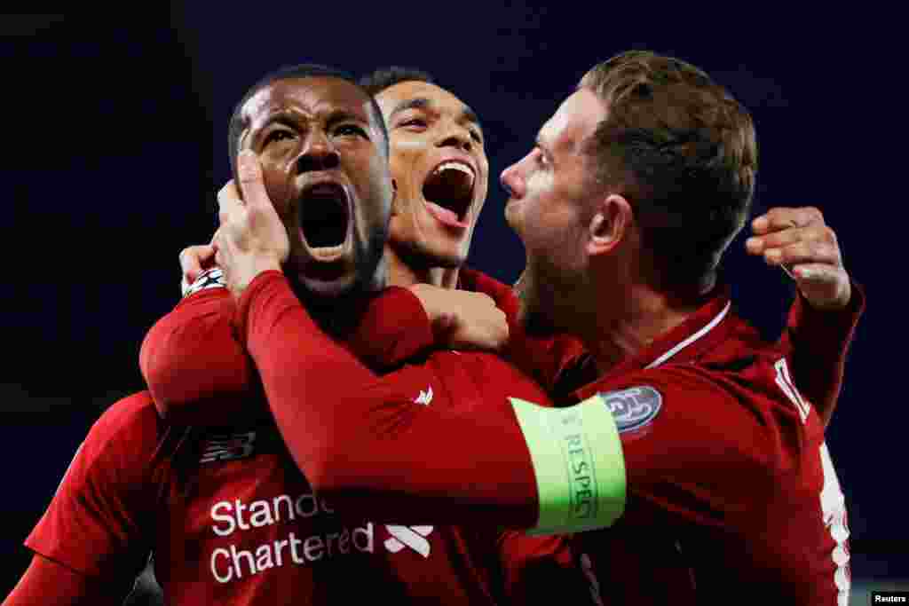 Liverpool's Georginio Wijnaldum celebrates scoring their third goal against Barcelona with Jordan Henderson and Trent Alexander-Arnold during the Champions League Semi Final Second Leg in Liverpool, Britain, May 7, 2019.