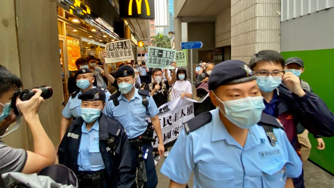 香港支聯會及社民連4名成員4月15日首個國家安全教育日遊行示威,被大批軍裝警員包圍 (美國之音湯惠芸)