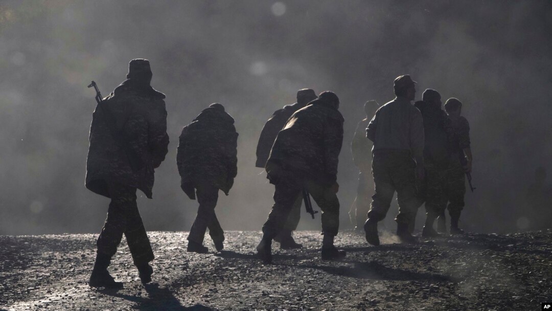 FILE - Armenian soldiers walk along a road near the border between Nagorno-Karabakh and Armenia, Nov. 8, 2020. 