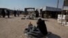 A woman shouts “Get out!” on the main street of the al-Hol Camp in Syria, Oct. 17, 2019. (Y. Boechat/VOA)