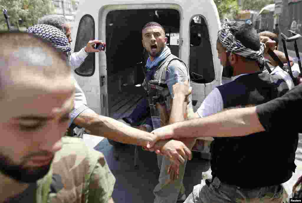 A Free Syrian Army fighter reacts after hearing news that his commander had been killed by tank shell in Aleppo, August 14, 2012.