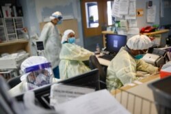 FILE - Emergency room doctors and nurses wear personal protective equipment due to COVID-19 concerns at St. Joseph's Hospital in Yonkers, New York, April 20, 2020.