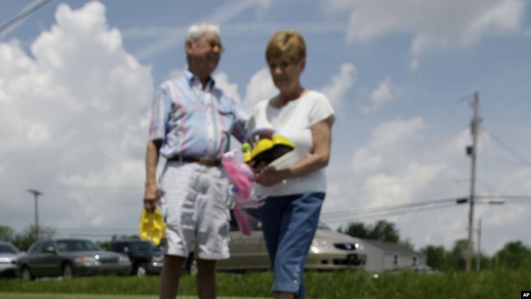 George Schatzlein y Linda Cripe buscan juguetes para niños en una venta de jardín en Greenfield, Indiana.