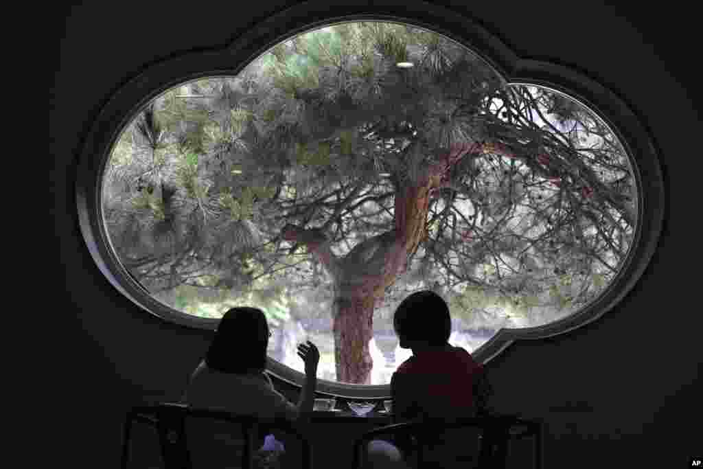 Visitors enjoy the scene from a window of the Xiangshan hotel designed by Chinese-American architect I.M. Pei and built in 1982 in Beijing, China.