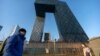 En esta foto del 4 de febrero de 2021, gente camina en Beijing más allá de la sede de la cadena de televisión estatal china CCTV y su brazo en el extranjero CGTN, que ha sido despojado de su licencia de radiodifusión en Reino Unido.