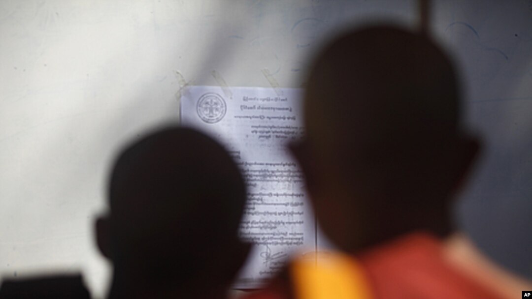 Buddhist monks look at a notice from the state committee of Sangha Maha Nayaka at the Shwenyawar monastery in Rangoon, December 15, 2011. The state committee of Sangha Maha Nayaka announced the removal of Pyi Nyar Thiha from the monastery after he preache