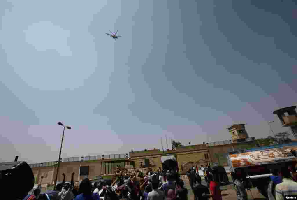 Supporters of deposed Egyptian president Hosni Mubarak gesture as the helicopter carrying him leaves Tora prison, Cairo, August 22, 2013.