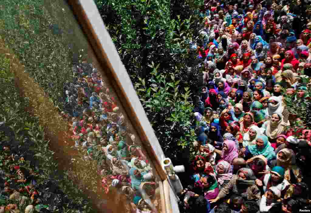 People watch the body of Imran Ahmad Bhat, a suspected militant who was killed during a gun battle with Indian security forces, during his funeral procession in Arihal village in South Kashmir's Pulwama district.