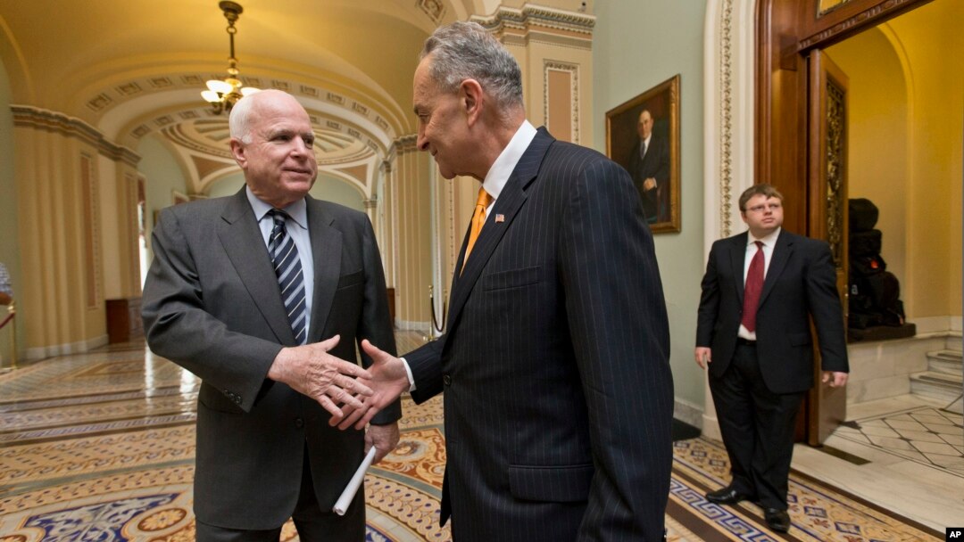 El senador John McCain (izq.) y su par demócrata Charles Schumer, parte del Grupo de los Ocho, celebran la aprobación de una reforma migratoria.