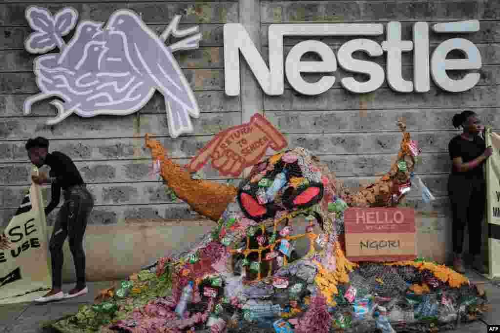 Activists of the environmental group Greenpeace Africa protest against Swiss food giant Nestle for its single-use plastic packages next to a 'plastic monster' object made with Nestle plastic packaging, at the entrance of Nestle's factory in Nairobi, Kenya.