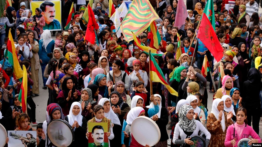 FILE - Protesters carry pictures of Abdullah Ocalan, the jailed leader of the Kurdistan Workers' Party (PKK), during a demonstration in support of Kurdish fighters and the besieged Syrian town of Kobani, in Aleppo, Syria, Nov. 1, 2014. 