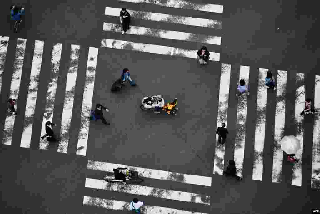 People cross a street in Tokyo's Ginza district, Japan.