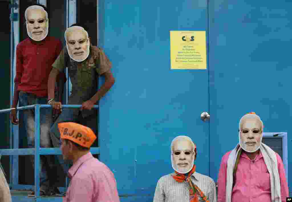 India's ruling Bharatiya Janata Party (BJP) supporters wearing masks of prime minister Narendra Modi. wait for his arrival during an election campaign rally in Prayagraj.