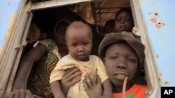 A South Sudanese family waits inside a train in Khartoum to be transported to Wau in South Sudan, March 1, 2012.