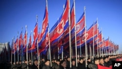 FILE - North Koreans parade with the North Korean flag in Kim Il Sung Square in Pyongyang to show their loyalty to the Workers' Party, Feb. 25, 2016. The resolution, drafted by the United States and introduced last Thursday, calls for a total arms embargo on Pyongyang.