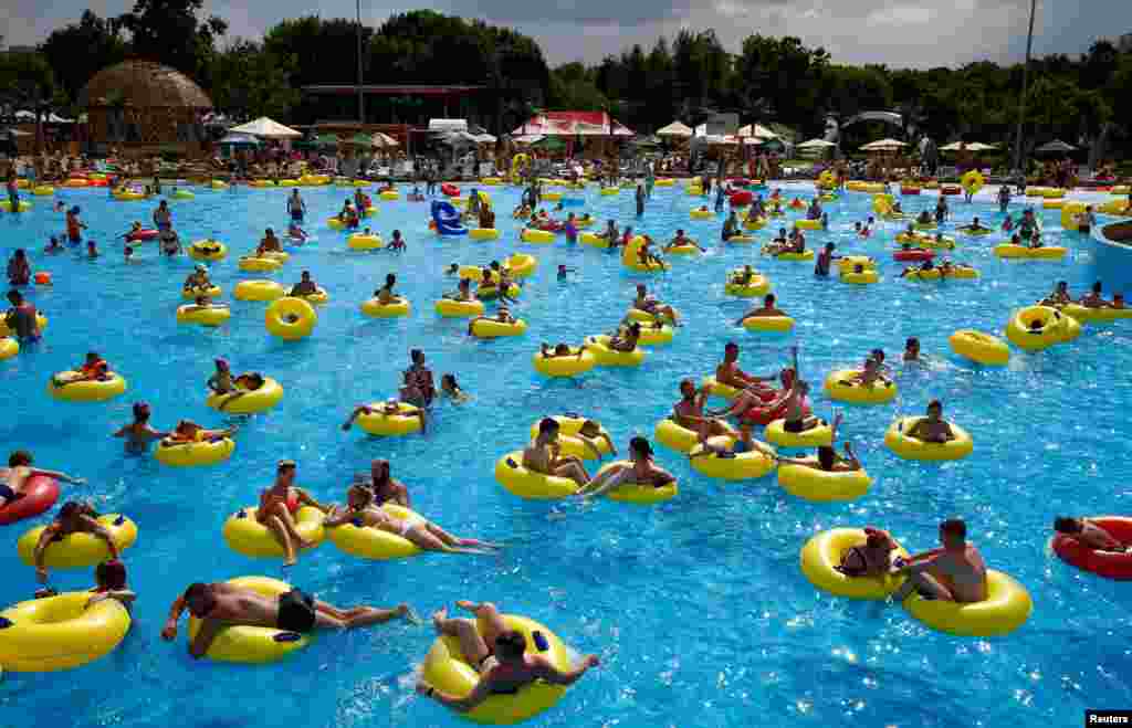 People cool down in water and amusement park 'Dreamland' during a hot day in Minsk, Belarus, June 8, 2019.