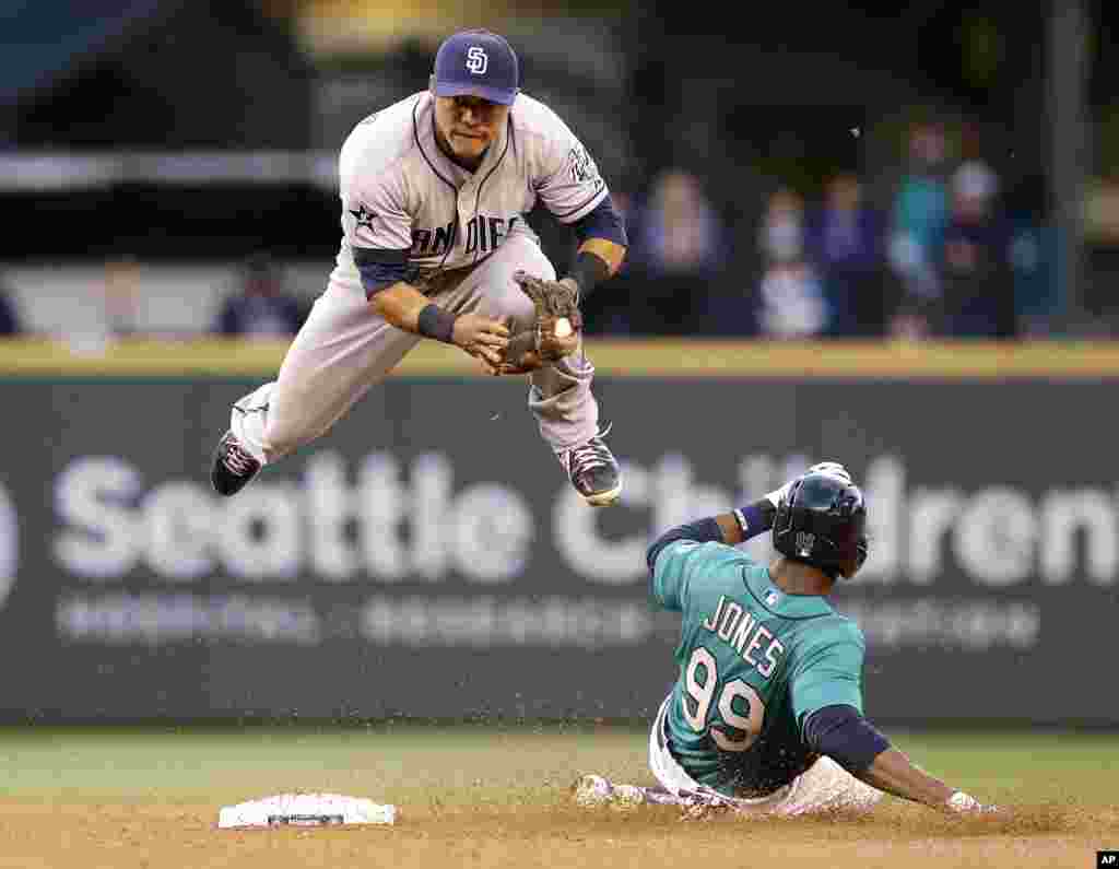 San Diego Padres second baseman Alexi Amarista leaps to get out of the way of sliding Seattle Mariners' James Jones (99) at second base in the fourth inning in a baseball game in Seattle, Washington, USA, June 16, 2014.