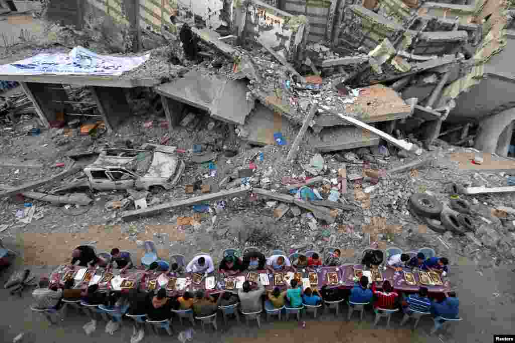 Palestinians break their fast during the holy month of Ramadan, near the rubble of a building recently destroyed by Israeli air strikes, in Gaza City, May 18, 2019.