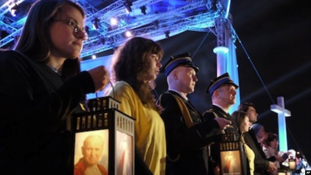 Faithful in Warsaw, Poland hold lanterns with an image of Pope John Paul II as they attend a prayer vigil honoring the late Pontiff on the eve of his beatification, Saturday, April 30, 2011.