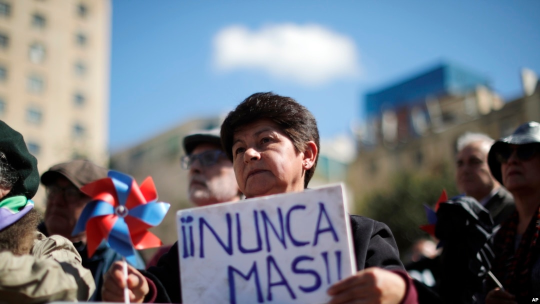 Una persona sostiene la frase "¡Nunca más!" en las afueras del palacio presidencial de La Moneda, durante una ceremonia que conmemora el 50 aniversario del golpe militar de 1973 que derrocó al presidente Salvador Allende, en Santiago, el 11 de septiembre de 2023.