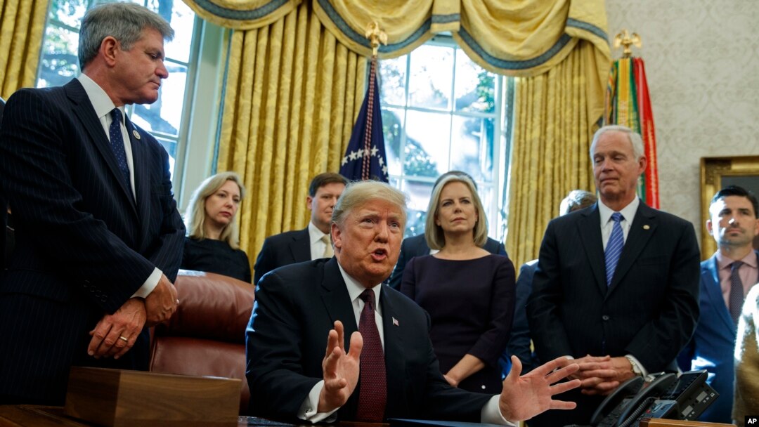 FILE - President Donald Trump answers a reporters question about the investigation of special counsel Robert Mueller during a signing ceremony of the "Cybersecurity and Infrastructure Security Agency Act," in the Oval Office of the White House, Nov. 16, 2018.