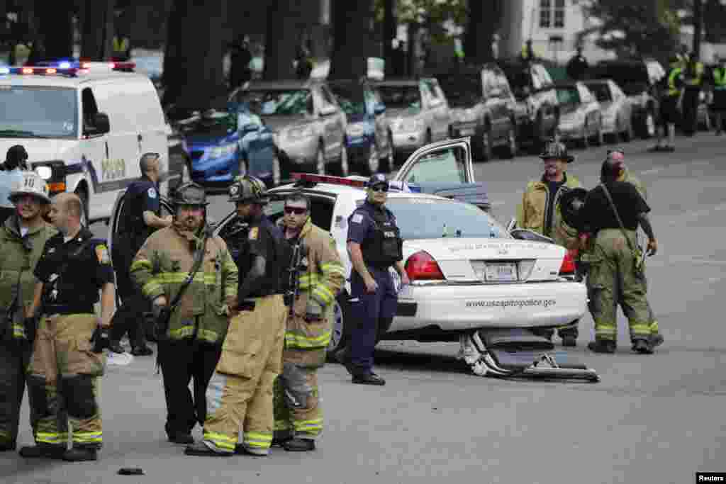 Emergency personnel stand near a police car after gunshots were fired outside the U.S. Capitol building.
