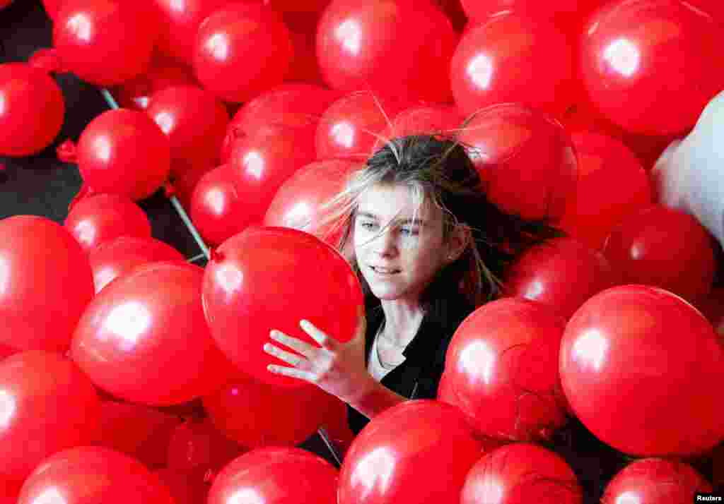 A girl is surrounded by balloons during Valentine's Day celebrations at the Riviera shopping mall in Moscow, Russia.